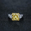 4-carat brilliant princess cut canary yellow diamond ring with three-stone halo design, ideal for weddings and luxury engagements.