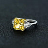 4-carat brilliant princess cut canary yellow diamond ring with three-stone halo design, ideal for weddings and luxury engagements.