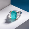 4 carat Paraiba blue three-stone ring in sterling silver and gold with an ocean-inspired design, ideal for engagements.