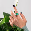 Green Emerald Halo Ring with vivid emerald cut stone, surrounded by a sparkling three stone, perfect for engagements and anniversary