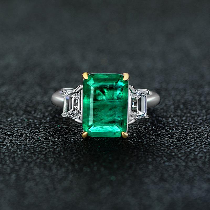 Green Emerald Halo Ring with vivid emerald cut stone, surrounded by a sparkling three stone, perfect for engagements and anniversary