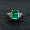 Green Emerald Halo Ring with vivid emerald cut stone, surrounded by a sparkling three stone, perfect for engagements and anniversary